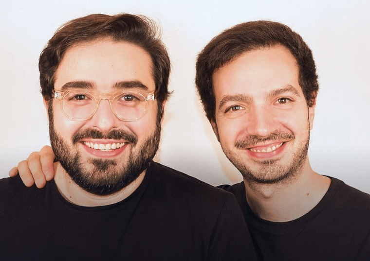 Lautaro Schiaffino and Ezequiel Sculli posing for a photo against a neutral background, both wearing black t-shirts.